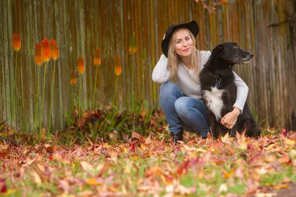 Mulher bonita com cão preto — Fotografia de Stock