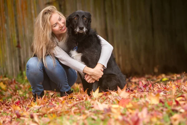 Mulher bonita com cão preto — Fotografia de Stock