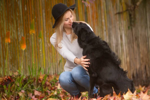 Mulher bonita com cão preto — Fotografia de Stock
