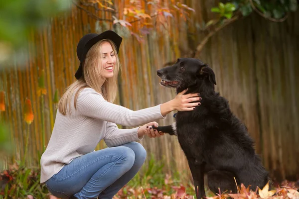 Mulher bonita com cão preto — Fotografia de Stock