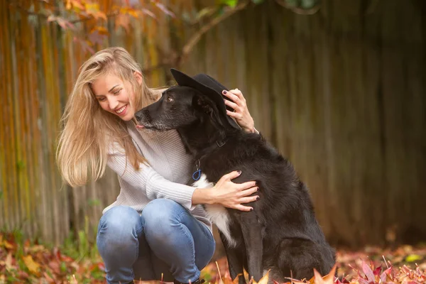 Mulher bonita com cão preto — Fotografia de Stock