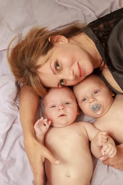 Retrato interior da mãe com seus gêmeos — Fotografia de Stock