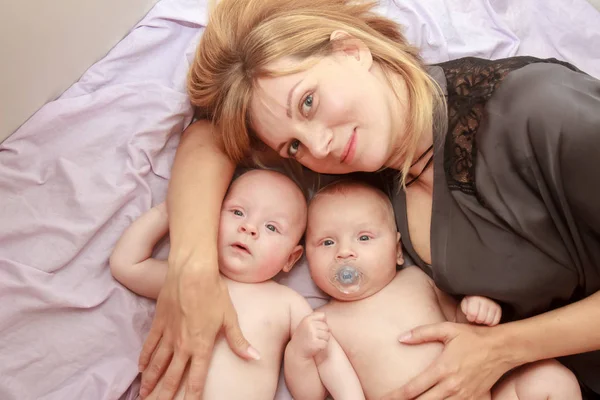 Retrato interior da mãe com seus gêmeos — Fotografia de Stock