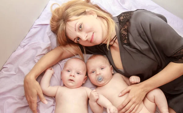 Indoor portret van een moeder met haar tweeling — Stockfoto