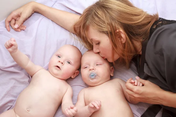 Indoor portrait of mother with her twins — Stock Photo, Image