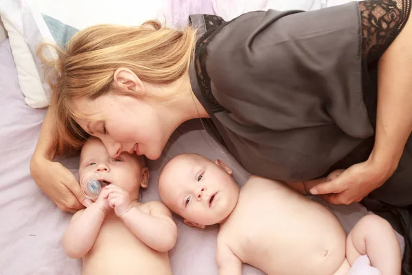 Indoor portrait of mother with her twins — Stock Photo, Image