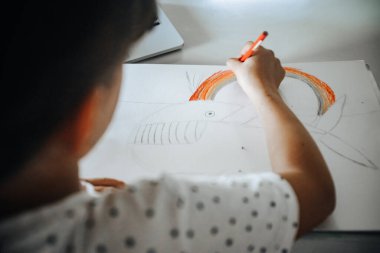 Evde çizim yapan beyaz bir kızın kapalı alanda portresi, evde eğitim, internette öğrenim.