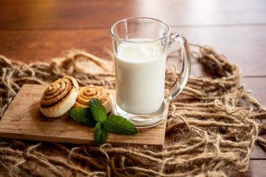 Ahşap zeminde taze pişmiş tarçınlı rulo.