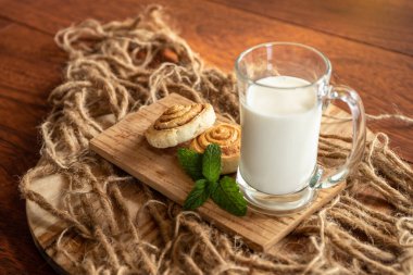 Ahşap zeminde taze pişmiş tarçınlı rulo.