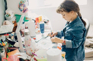 Evde el işi yapan genç kız portresinin yatağında dizüstü bilgisayarlı sıradan bir portresi.