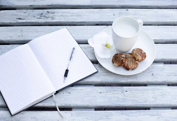 Taza Leche Galletas Cuaderno Azul Sobre Fondo Blanco Madera — Foto de Stock