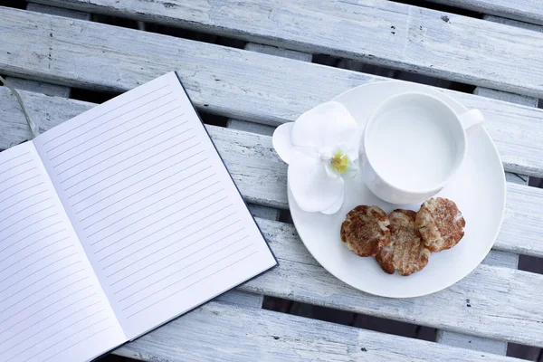 Taza Leche Galletas Cuaderno Azul Sobre Fondo Blanco Madera — Foto de Stock