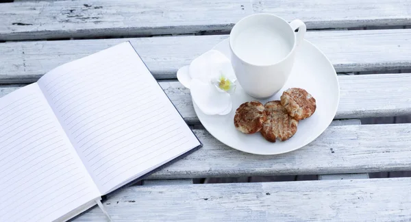 Taza Leche Galletas Cuaderno Azul Sobre Fondo Blanco Madera — Foto de Stock