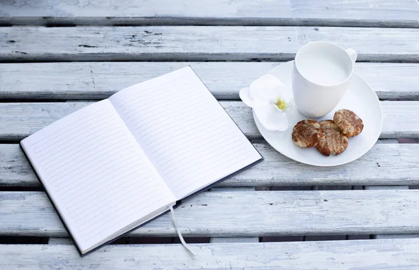 Taza Leche Galletas Cuaderno Azul Sobre Fondo Blanco Madera — Foto de Stock