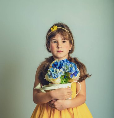 Sade arka planda izole edilmiş çiçeklerle çocuk gril 'inin kapalı stüdyo portresi