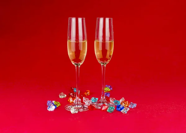 Bicchieri di champagne su sfondo rosso con pietre di cristallo scintillante sulla base. Anno nuovo o celebrazione romantica. Lusso. Spazio libero — Foto Stock