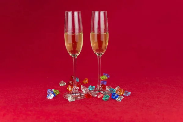 Copas de champán sobre fondo rojo con piedras de cristal brillante en la base. Año nuevo o celebración romántica. Lujo. Espacio libre Imágenes De Stock Sin Royalties Gratis