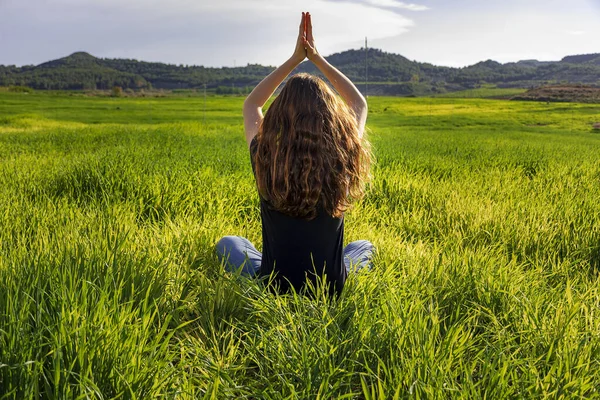 Jovem caucasiana ruiva, com cabelos longos e sardas, sentada na grama em uma posição de ioga. mindfulness, meditação e cena relaxante — Fotografia de Stock