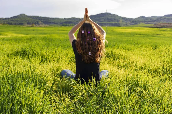 Jovem caucasiana ruiva, com cabelos longos e sardas, sentada na grama em uma posição de ioga. mindfulness, meditação e cena relaxante — Fotografia de Stock