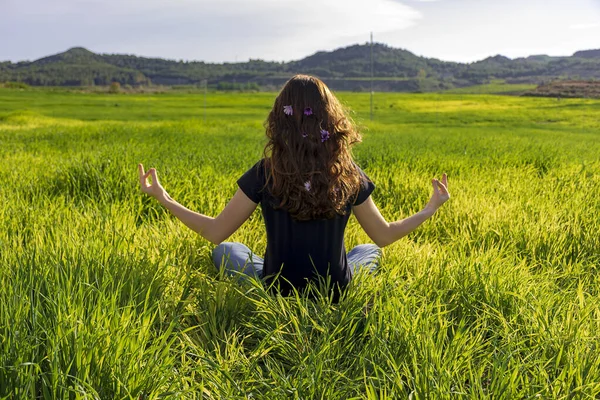 Jovem caucasiana ruiva, com cabelos longos e sardas, sentada na grama em uma posição de ioga. mindfulness, meditação e cena relaxante — Fotografia de Stock