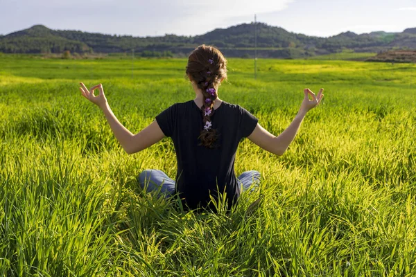 Fiatal, fehér, vörös hajú nő, hosszú hajjal és szeplőkkel, jóga pozícióban ül a fűben. figyelem, meditáció és pihentető jelenet — Stock Fotó