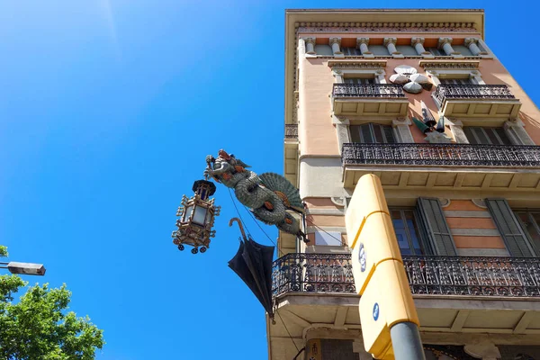 Барселона, Испания, Европа - фасад здания и характерная лампа с драконом и зонтиком — стоковое фото