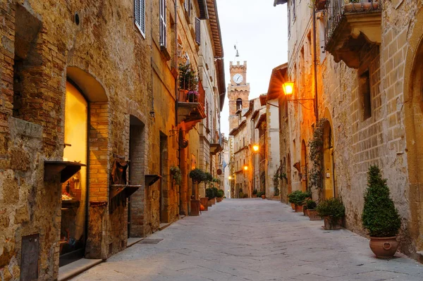 Pienza, Toskánsko, Itálie - starověké ulice s kamennými budovami, v pozadí zvonice radnice — Stock fotografie