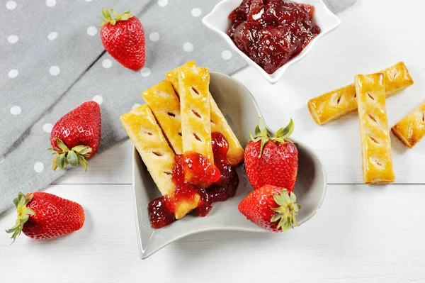 Сладкая еда - клубничные фрукты и варенье и слоеное печенье — стоковое фото