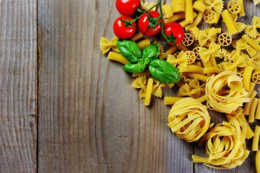 Domates, fesleğen ve İtalyan makarna rigatoni, fettuccine, penne, ahşap arka plan üzerinde farfalle