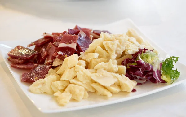 Пармезанський сир, холодні нарізки та червоний цикорійний салат у тарілці — стокове фото