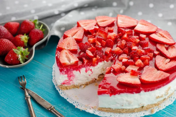 Клубника летом свежие красные фрукты и вкусный десертный торт на синем деревянном фоне — стоковое фото