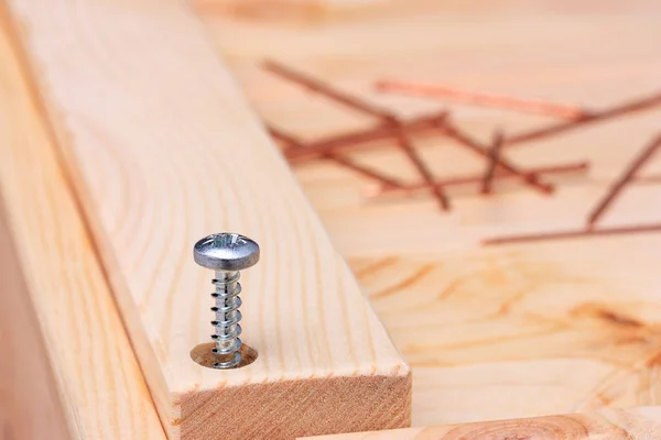 El tornillo está medio torcido en una tabla de madera . —  Fotos de Stock