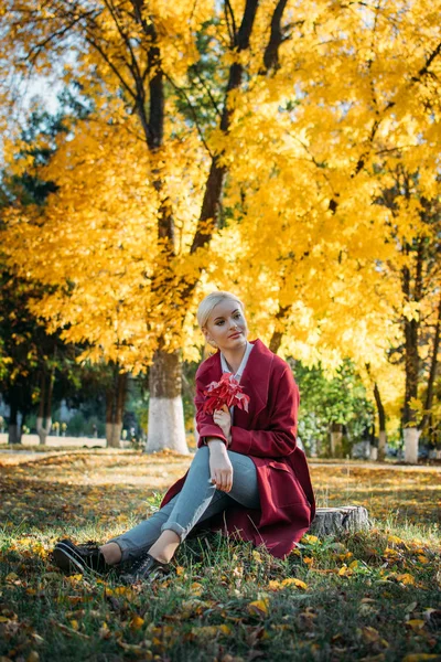 Adorable blonde fashion girl in fall Autumn park. Portrait of beautiful girl in burgundy coat. Fall fashion trend — Stock Photo, Image