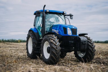 Yeni mavi traktör Holland, Agroexpo tarım sergisindeki gösteri alanında hareket halinde. Çiftlikte çalışan traktör, modern tarım taşımacılığı. Kropivnitskiy, Ukrayna, 27 Eylül 2018