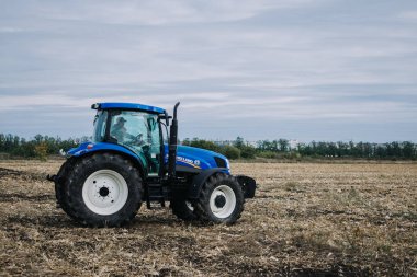 Yeni mavi traktör Holland, Agroexpo tarım sergisindeki gösteri alanında hareket halinde. Çiftlikte çalışan traktör, modern tarım taşımacılığı. Kropivnitskiy, Ukrayna, 27 Eylül 2018