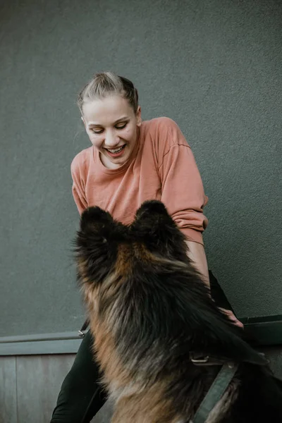 Pet Love. Młoda, bardzo szczęśliwa kobieta bawi się z owczarkiem niemieckim. Autentyczne chwile radosnej dziewczyny bawiącej się psami. Pet love, koncepcja treningu psów — Zdjęcie stockowe