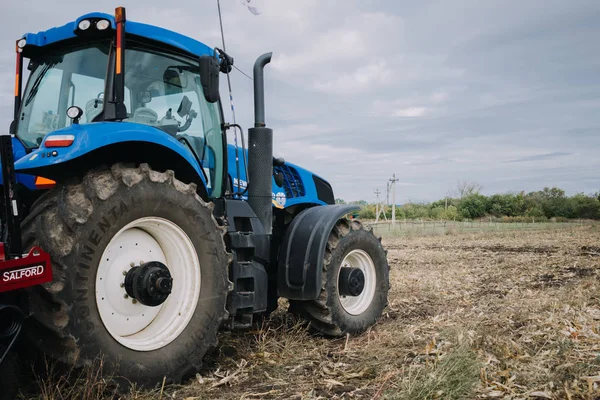 Nowy niebieski traktor Holandia w ruchu na terenie pola demonstracyjnego na targach agro Agroexpo. Ciągnik pracujący w gospodarstwie, nowoczesny transport rolniczy. Kropivnitskiy, Ukraina, 27 września 2018 — Zdjęcie stockowe