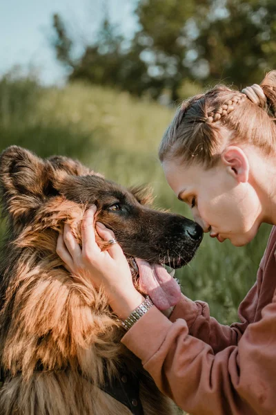 Zvířecí láska. Mladá docela šťastná žena hraje s německým ovčáckým psem. Autentické okamžiky radosti dívka hraje se svými psy. Zvířecí láska, koncepce výcviku psů — Stock fotografie