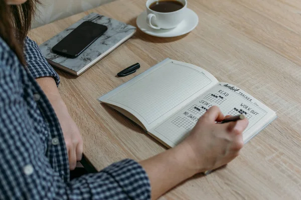 Mermi Günlük Alışkanlık İzleyici. Alışkanlık takip cihazıyla günü silip atan kadın. Seçici odak.