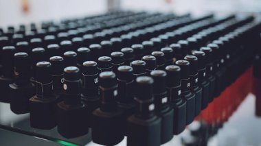 Birçok jöle ojeli siyah şişe arka planı. Jel tırnak prosedürü için malzemeler. Çivi kaplaması için jöle-cila şişeleri..