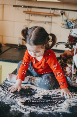 Coronavirus Karantinası 'ndaki çocuklar için etkinlikler. Aileler, karantinada çocukları nasıl meşgul ediyor? Anne ve küçük kızı mutfakta oynuyorlar..