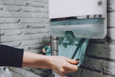 Coronavirus hijyeni. Tuvalette kağıt havlu ve alkol jeli antibakteriyel sabun dezenfektanı var. Kadın ellerini ve mendillerini kağıt havluyla yıkıyor.