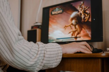 Evde World of Warcraft oynamak için bilgisayar kullanan yetişkin erkek oyuncunun arka planı. Kişisel Karantina ve Sosyal Mesafedeki Yetişkinler İçin Oyunlar.