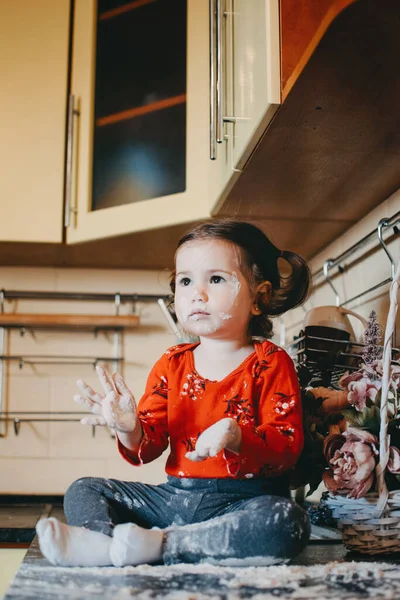 Mehl sensorisches Spiel für Kleinkinder. Leichtes Mehl sensorische Spielaktivität für Babys. Nettes kleines Mädchen sitzt auf Küchentisch und spielt mit Mehl — Stockfoto