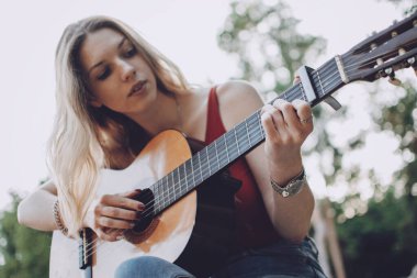 Gitar çalmayı öğreniyorum. Acemi Gitar Dersi. Kadın elinin akustik gitar çalarkenki yakın çekimi. Müzik eğitimi ve müfredat dışı dersler.