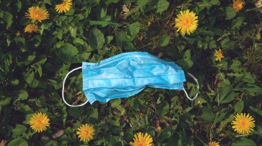 Coronavirus Trash: Yüz maskeleri, Plastik Eldivenler Sokağa Döküldü. Çimlerde bırakılan tıbbi maskeler kullanılmış..