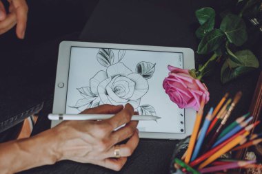 İPad 'de dövme sanatı dijital süreci. Ellerinde Apple kalem tutan ve üreme sürecinde iPad Pro 'da çizen dövme sanatçısı elleri. Kropivnitskiy, Ukrayna, 27 Eylül 2019