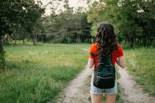 Sustainable Tourism, focus on local, domestic tourism. Female traveller young girl tourist walking on country road.