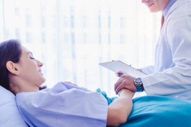 Doktor hasta elini tutuyor, ona güvende olduğunu ve kanserden kurtulacağını söylüyor. Doktor hasta odasında yatağın yanına oturup hasta kadını cesaretlendiriyor. Hasta kadın mutlu olur, stresten kurtulur.