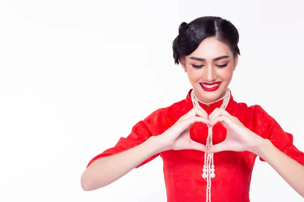 Beautiful chinese woman making heart shape by using hands to give to people or customer with smiley face. Charming beautiful asian young lady wear chinese dress, apply nice makeup in china new year. — Stockfoto